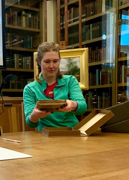 A woman holding a book in a library