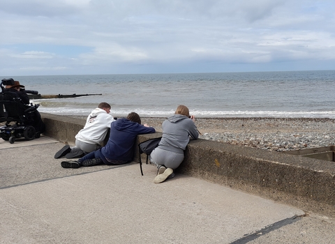 Three people on the sea wall looking out to sea