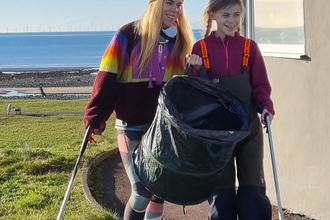 Mother and child doing a beach clean.