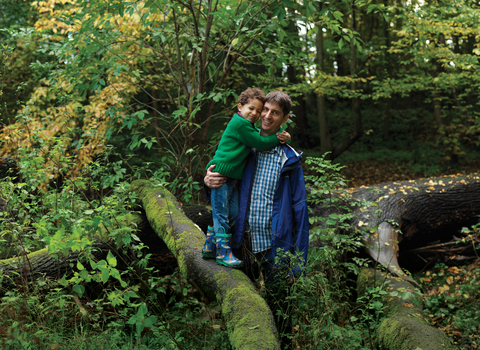 Father and son standing on a tree branch