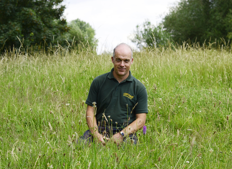 man sitting in field wildlife trust